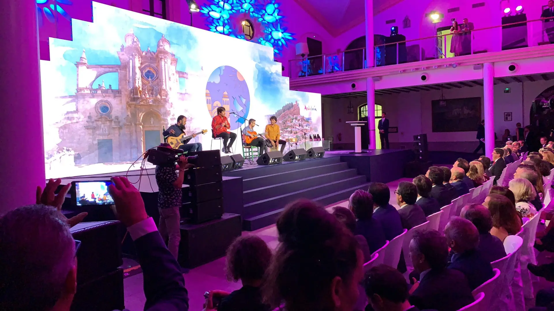 Actuación musical en directo durante una gala, con pantalla LED y público