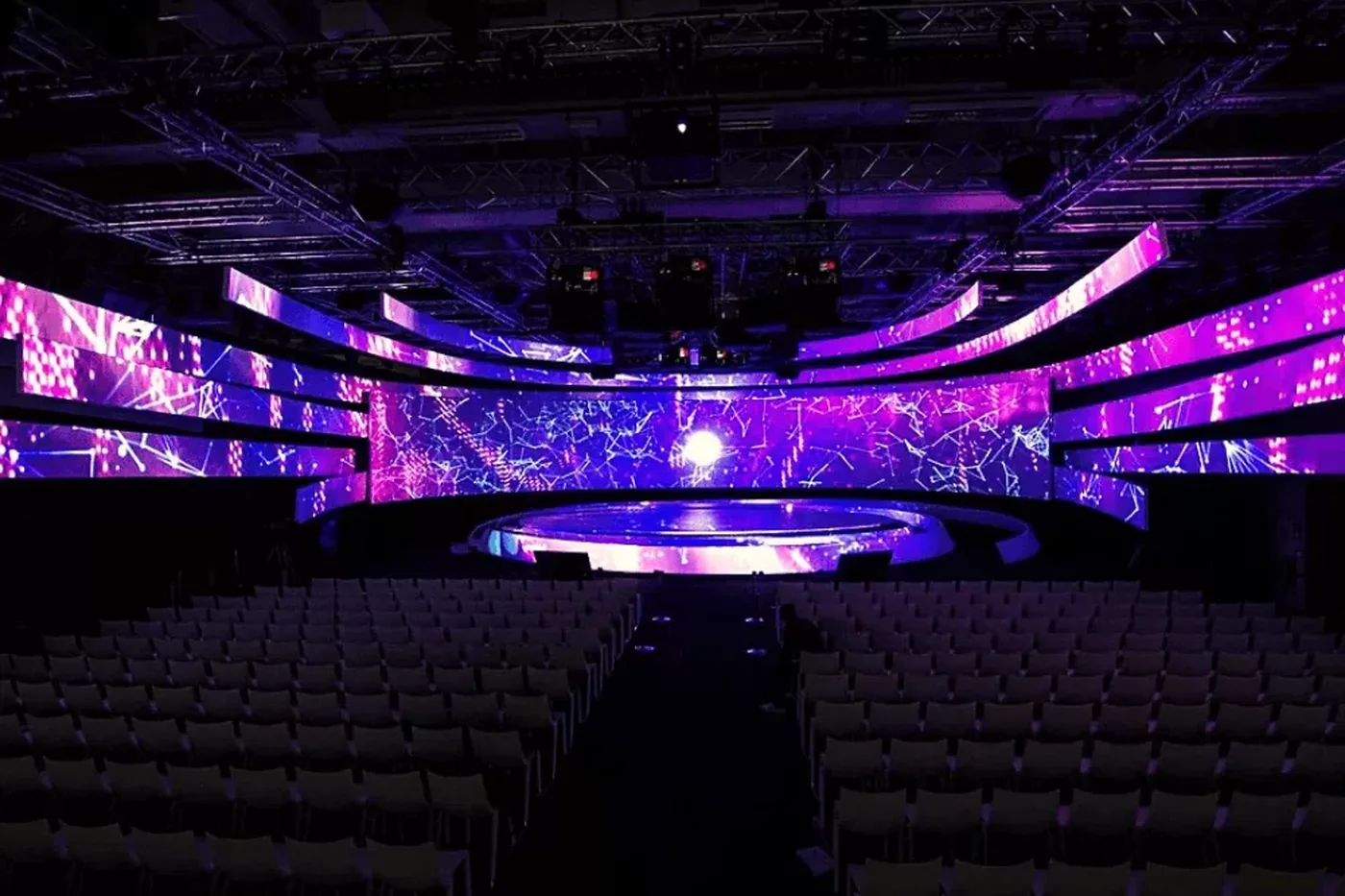 Escenografía de pantallas LED curvas envolviendo el escenario de un auditorio